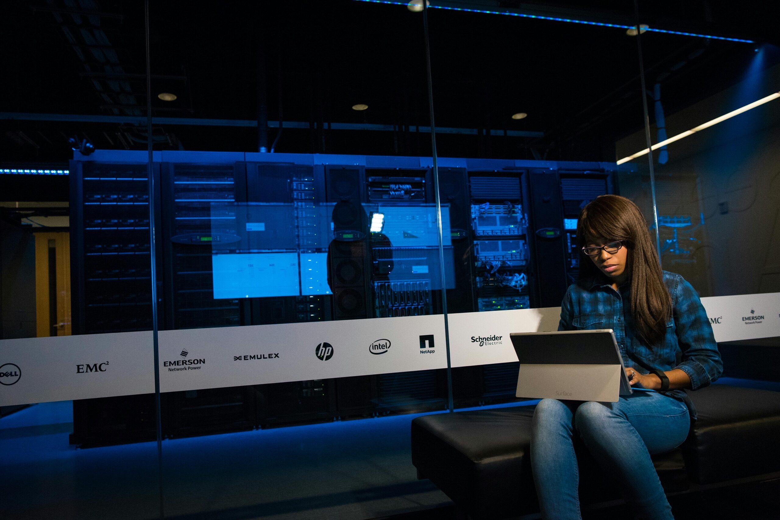 ITSco security specialist working beside a monitored server room