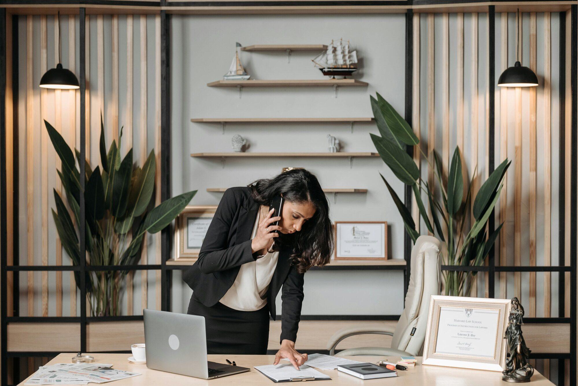 Attorney taking a call in a modern office with case files and a laptop
