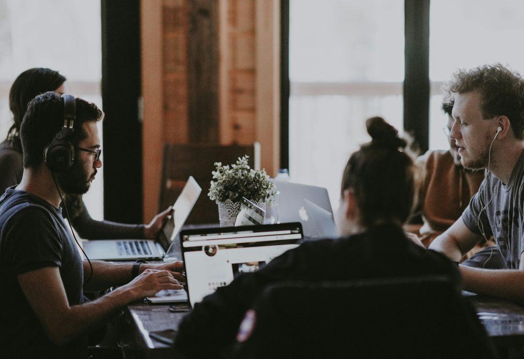 Team collaborating around laptops in a modern workspace